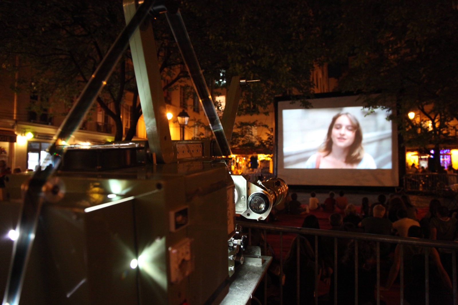 Proyección de cine al aire libre en una pantalla hinchable «Hallucine», con el proyector de cine en primer plano